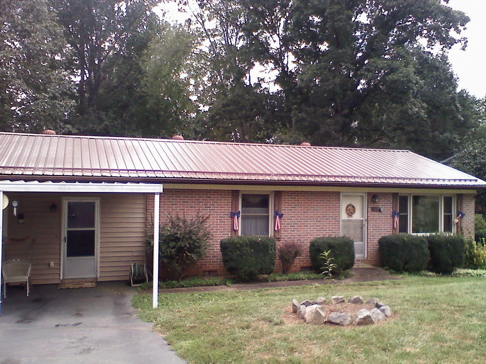 Bronze metal roof and carport on a brick ranch home — Roof Repair work by our crew in Edgar